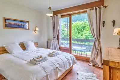 a bedroom with a bed and a large window at Appartement Cosy, Chamonix Centre in Chamonix-Mont-Blanc