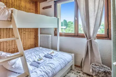 a bunk bed in a room with a window at Appartement Cosy, Chamonix Centre in Chamonix-Mont-Blanc