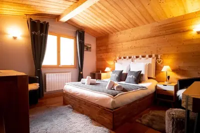 a bedroom with a bed in a wooden room at Refuge des Alpages - Duplex - Vue Aiguillette des Houches in Les Houches