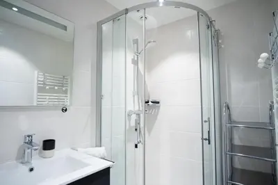 a white bathroom with a shower and a sink at Refuge des Alpages - Duplex - Vue Aiguillette des Houches in Les Houches