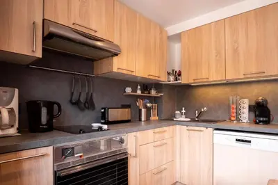 a kitchen with wooden cabinets and a stove top oven at Refuge des Alpages - Duplex - Vue Aiguillette des Houches in Les Houches