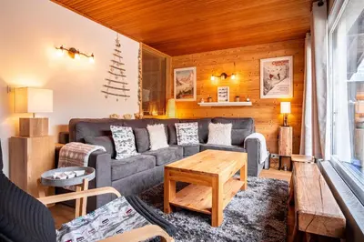 a living room with a couch and a table at Refuge des Alpages - Duplex - Vue Aiguillette des Houches in Les Houches
