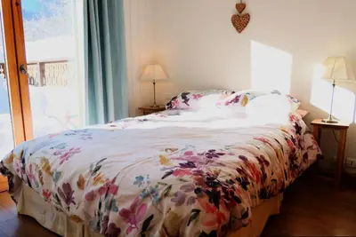 a bedroom with a bed with a floral comforter at Vue splendide Mont Blanc in Saint-Gervais-les-Bains