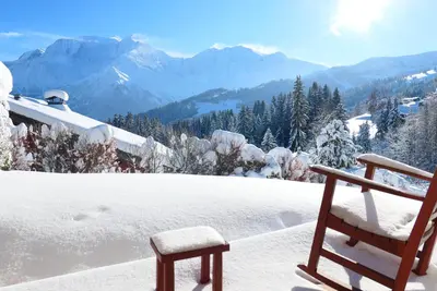 a wooden bench sitting on top of a snow covered mountain at Vue splendide Mont Blanc in Saint-Gervais-les-Bains