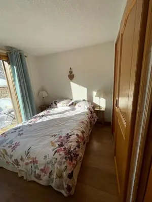 a bedroom with a bed with a floral bedspread at Vue splendide Mont Blanc in Saint-Gervais-les-Bains