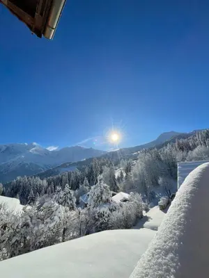 a view of a snowy mountain with the sun in the sky at Vue splendide Mont Blanc in Saint-Gervais-les-Bains