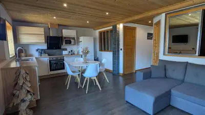 a living room and kitchen with a couch and a table at Les Hauts de Sallanches in Sallanches
