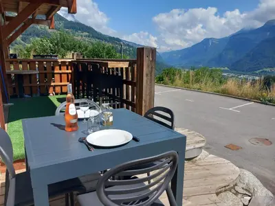 a blue table on a patio with a view of mountains at Les Hauts de Sallanches in Sallanches