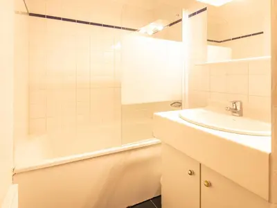 a white bathroom with a sink and a bath tub at Les Eterlous- 19- Appart pied des pistes- 6 pers in Morillon