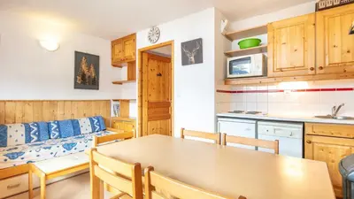 a kitchen and dining room with a table and a couch at Les Eterlous- 19- Appart pied des pistes- 6 pers in Morillon