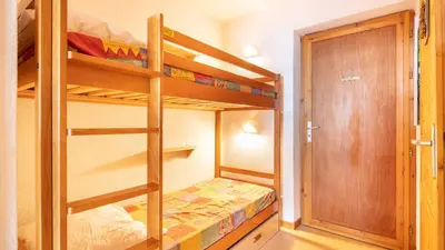 a small room with bunk beds and a door at Les Eterlous- 19- Appart pied des pistes- 6 pers in Morillon