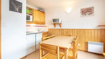 a small kitchen with a table and a microwave at Les Eterlous- 19- Appart pied des pistes- 6 pers in Morillon