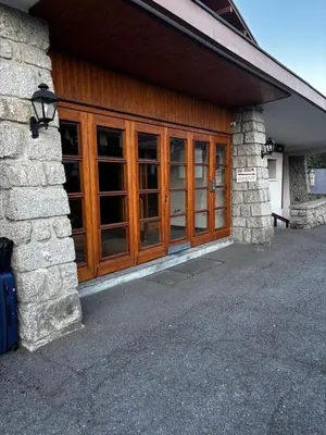 a building with wooden doors and a stone wall at SebRem in Megève