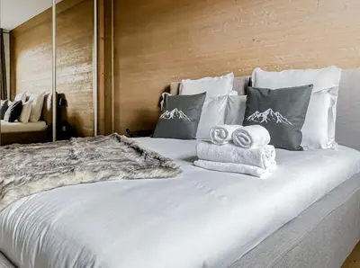 a large white bed with towels on top of it at Stallion d15 MEGEVE in Megève