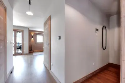 an empty hallway with white walls and wooden floors at Stallion d15 MEGEVE in Megève