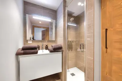 a bathroom with a shower and a sink and a mirror at Stallion d15 MEGEVE in Megève