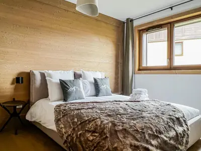 a bedroom with a large bed with pillows and a window at Stallion d15 MEGEVE in Megève
