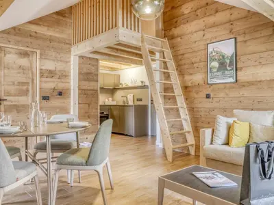 a living room with wooden walls and a spiral staircase at Studio cosy avec mezzanine, proche centre et télécabine - 2 pers. - FR-1-663-20 in Saint-Gervais-les-Bains