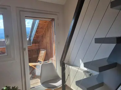 a white chair sitting on the balcony of a house at Vue magique in Sallanches