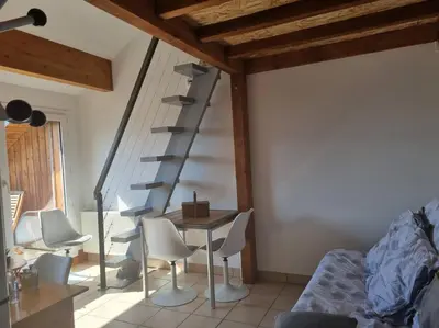 a room with a staircase and chairs and a table at Vue magique in Sallanches