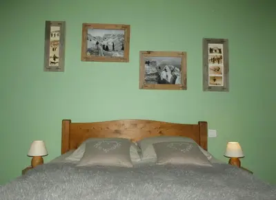 a bedroom with a bed with three pictures on the wall at SUPERBE DEMI CHALET LUXUEUX 120M² 8 Personnes à SALLANCHES. in Sallanches