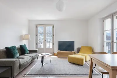a living room with a couch and a tv at Conseil B - Chic 2BR City Center Apartment - Free Parking & Mountain View - By Cozee Rentals in Saint-Gervais-les-Bains