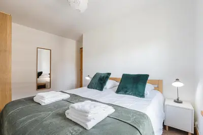 a bedroom with a large bed with green pillows at Conseil B - Chic 2BR City Center Apartment - Free Parking & Mountain View - By Cozee Rentals in Saint-Gervais-les-Bains