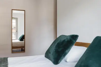 a bedroom with a mirror and a bed with a pillow at Conseil B - Chic 2BR City Center Apartment - Free Parking & Mountain View - By Cozee Rentals in Saint-Gervais-les-Bains