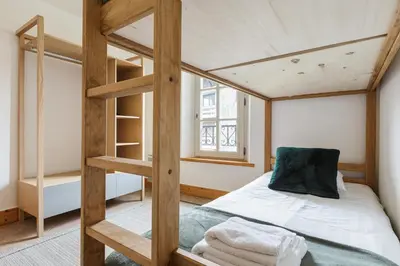 a bedroom with a bunk bed with a ladder at Conseil B - Chic 2BR City Center Apartment - Free Parking & Mountain View - By Cozee Rentals in Saint-Gervais-les-Bains