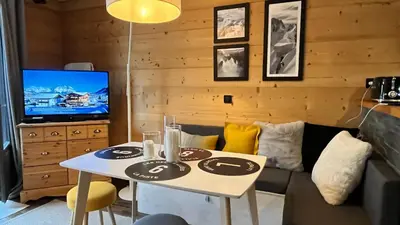 a living room with a table and a couch at Le 41 du Lyret - Appartement type studio pour deux avec vue sur les Aiguilles dans Chamonix Centre in Chamonix-Mont-Blanc