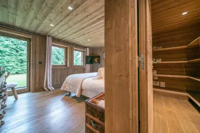 a bedroom with a bed in a wooden house at Chalet des Ours I Le Chalet Club in Megève