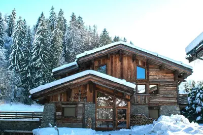 a log cabin with snow on the roof at Chalet des Ours I Le Chalet Club in Megève