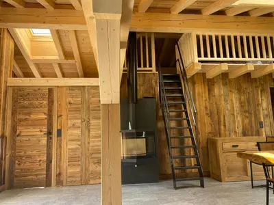 a room with a wooden ceiling with a ladder at chalet du Champel jacuzzi in Saint-Gervais-les-Bains