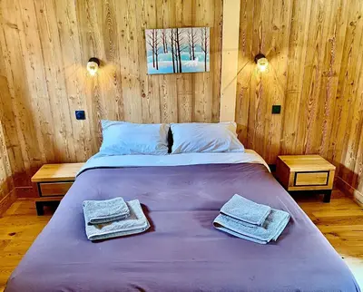 a bedroom with a large bed with two towels on it at chalet du Champel jacuzzi in Saint-Gervais-les-Bains