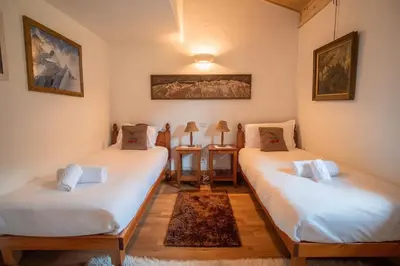 two twin beds in a room with white sheets at Chalet Vorgeats 2 - 6 pers - Au pied de la Flégère - Golf - UTMB in Chamonix-Mont-Blanc