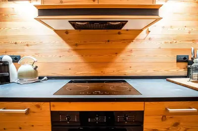 a stove top in a kitchen with wooden walls at Chalet Vorgeats 2 - 6 pers - Au pied de la Flégère - Golf - UTMB in Chamonix-Mont-Blanc