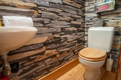 a bathroom with a toilet and a stone wall at Chalet Vorgeats 2 - 6 pers - Au pied de la Flégère - Golf - UTMB in Chamonix-Mont-Blanc