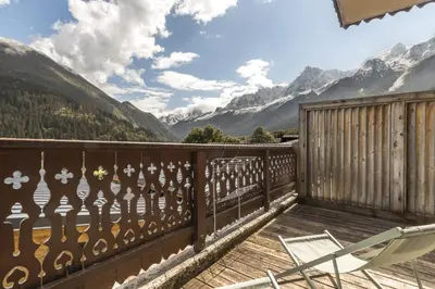 a balcony with a chair and a view of mountains at Appartement Bellevue Au pied des pistes in Les Houches