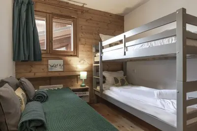 a bedroom with two bunk beds and a couch at Appartement Bellevue Au pied des pistes in Les Houches