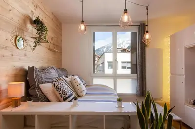 a living room with a bench and a window at Chailloud - Modern Studio 2pax - Lively Area - TV Wifi in Chamonix-Mont-Blanc