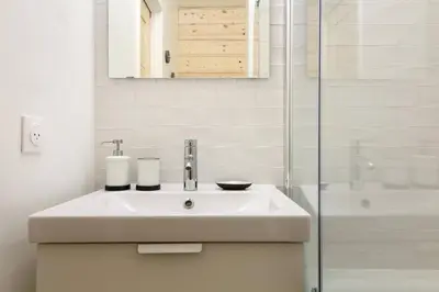 a white bathroom with a sink and a shower at Chailloud - Modern Studio 2pax - Lively Area - TV Wifi in Chamonix-Mont-Blanc