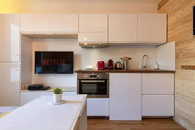 a kitchen with white cabinets and a counter top at Chailloud - Modern Studio 2pax - Lively Area - TV Wifi in Chamonix-Mont-Blanc