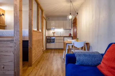 a living room with a blue couch and a table at Le Cry - Cosy studio 2pax - Free Parking - 5mn City Center in Chamonix-Mont-Blanc