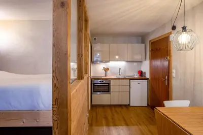 a kitchen with a bed and a kitchen with a table at Le Cry - Cosy studio 2pax - Free Parking - 5mn City Center in Chamonix-Mont-Blanc