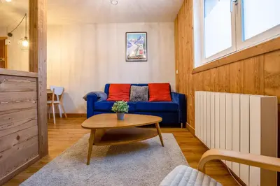 a living room with a blue couch and a table at Le Cry - Cosy studio 2pax - Free Parking - 5mn City Center in Chamonix-Mont-Blanc