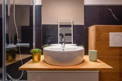 a bathroom with a large white sink on a wooden counter at Le Cry - Cosy studio 2pax - Free Parking - 5mn City Center in Chamonix-Mont-Blanc