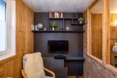 a living room with a tv and a chair at Le Cry - Cosy studio 2pax - Free Parking - 5mn City Center in Chamonix-Mont-Blanc