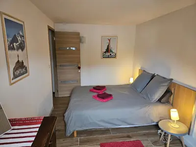 a bedroom with a bed with red towels on it at Appartement hyper centre, idéal pour 4 pers possibilité 6 couchages in Chamonix-Mont-Blanc