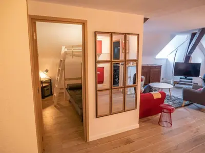 a view of a living room with a mirror at Appartement hyper centre, idéal pour 4 pers possibilité 6 couchages in Chamonix-Mont-Blanc