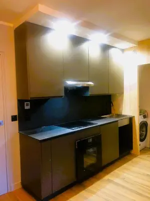a kitchen with a black counter top with lights at Base Camp Chamonix Vue Mont Blanc Centre Ville in Chamonix-Mont-Blanc